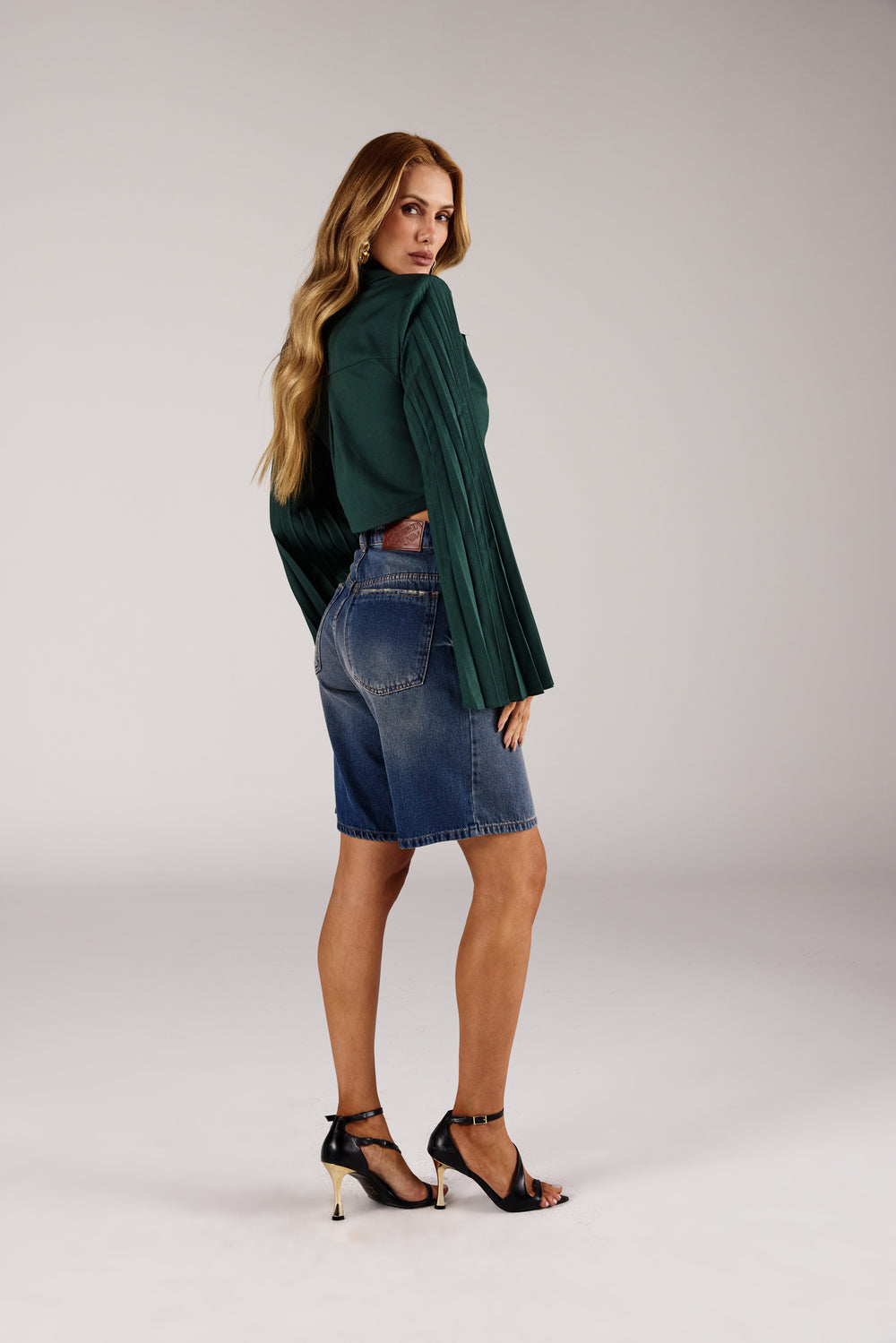 Bermuda jorts jeans lavagem vintage azul médio, look de frente com blazer verde Onça Preta
