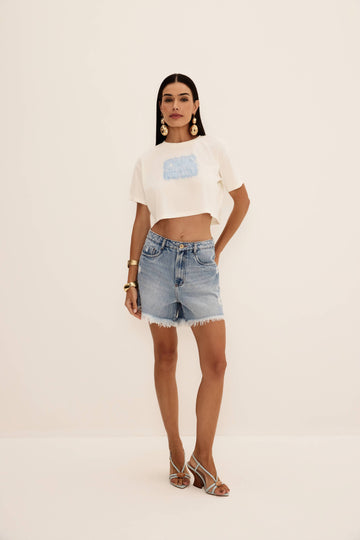 Bermuda com puídos jeans vista de frente, com cinco bolsos, puídos laterais e barra desfiada