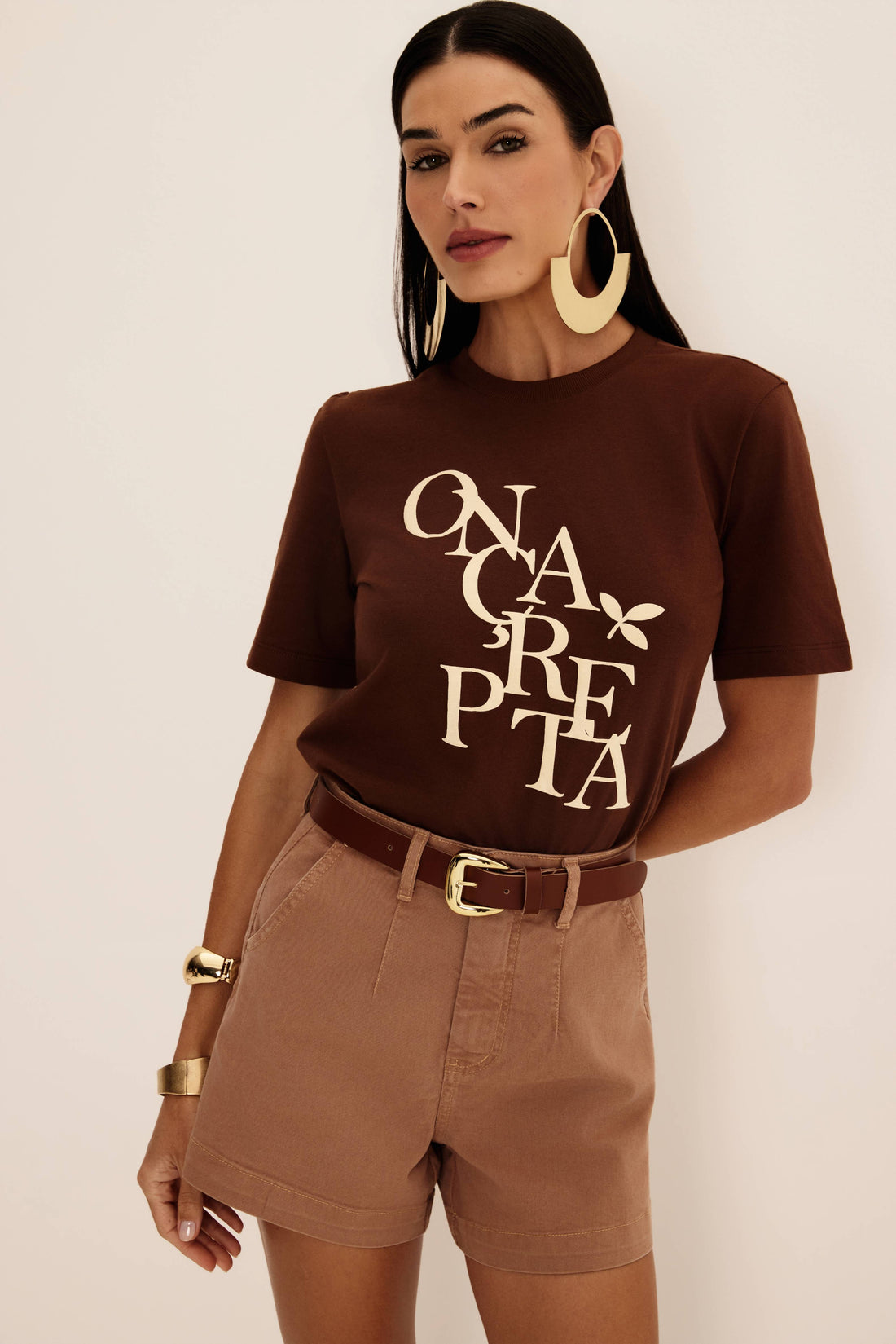 Bermuda jeans bege com pence frontal e cintura alta, look frontal com t-shirt marrom e cinto de couro Onça Preta