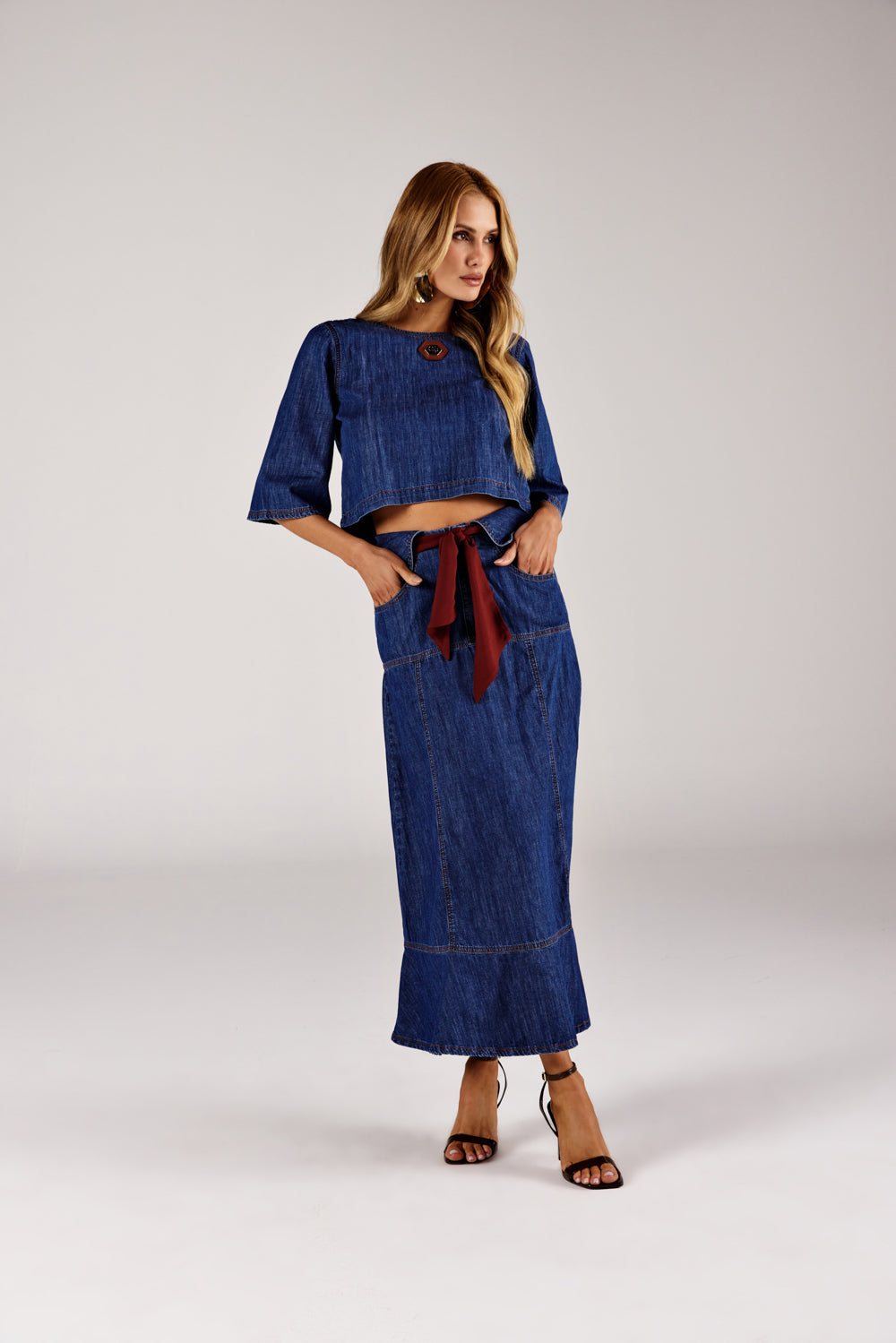 Blusa jeans cropped fluida azul escuro, look de frente com saia jeans Onça Preta