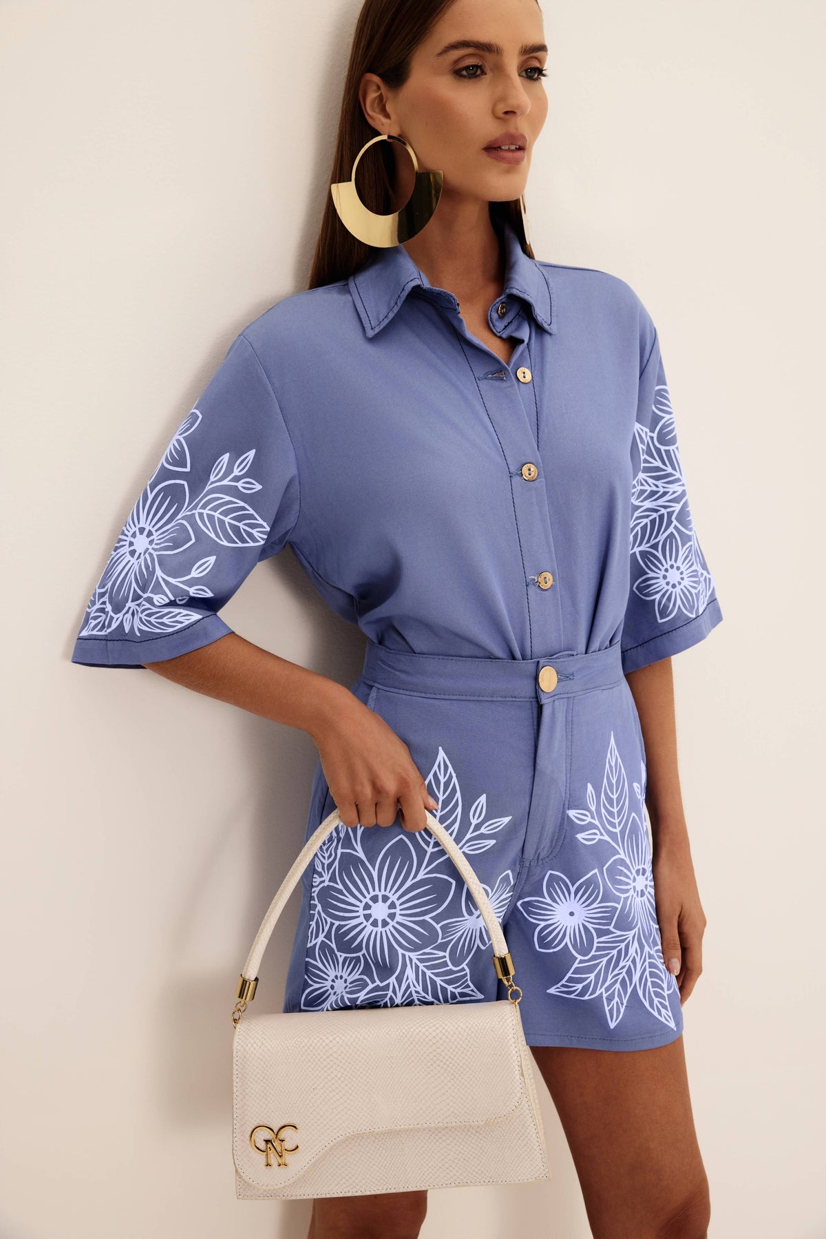 Camisa com aplicação puff jeans azul vista de frente, com gola, botões e flores em relevo nas mangas