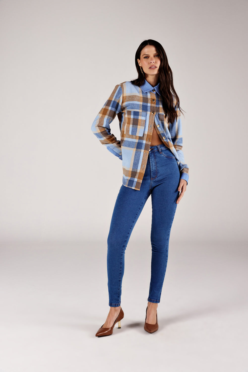  Calça super skinny jeans azul médio recorte no bolso, look de frente com flanela xadrez Onça Preta