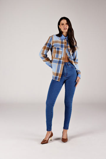  Calça super skinny jeans azul médio recorte no bolso, look de frente com flanela xadrez Onça Preta