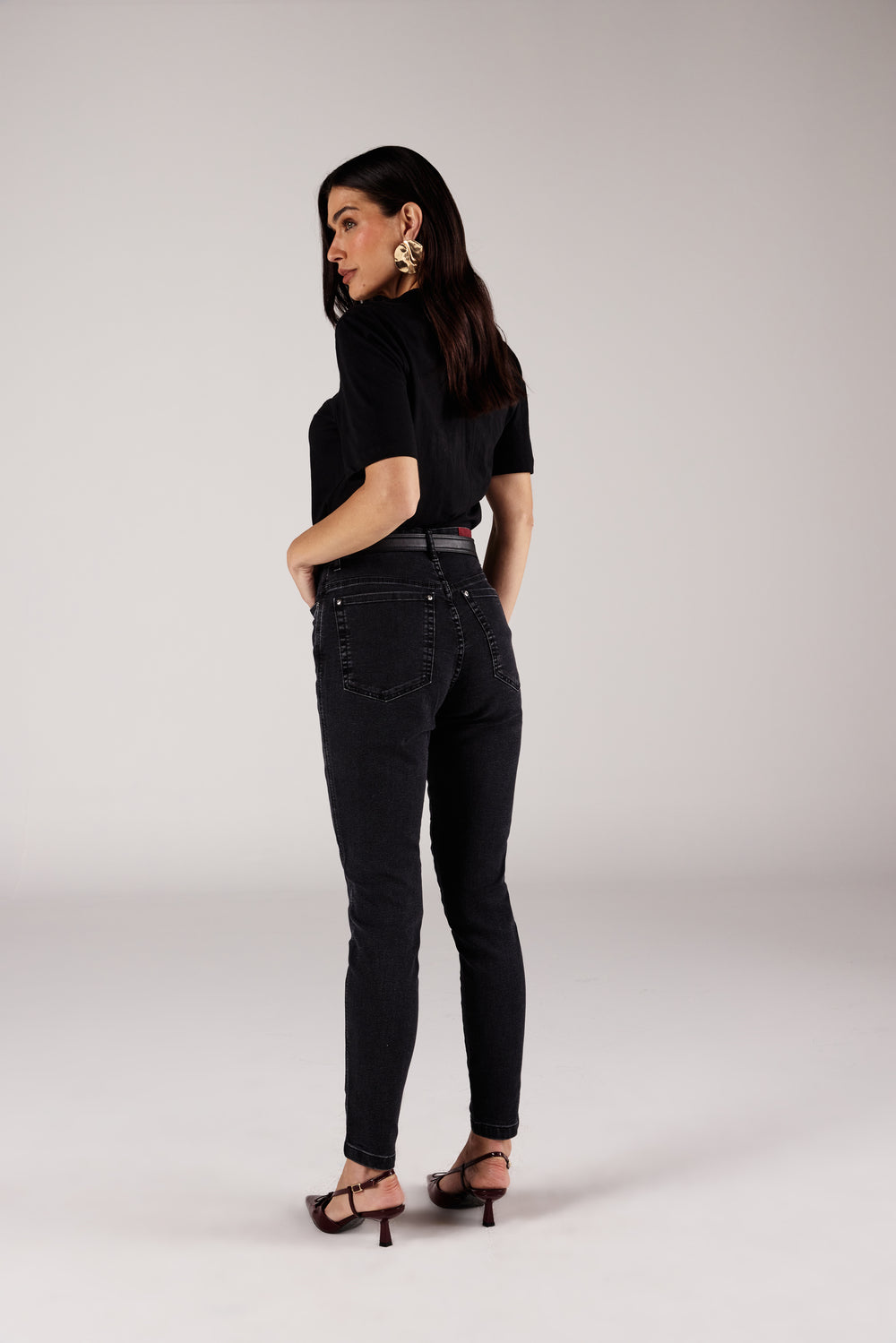 Calça skinny jeans cinza chumbo lavagem stone, vista traseira com t-shirt estampada Onça Preta