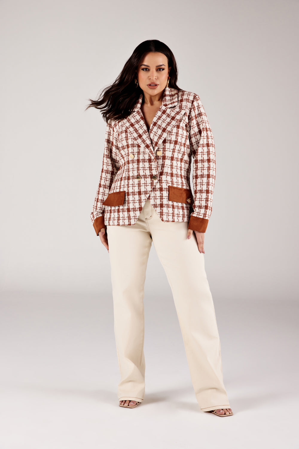 Calça reta jeans off white modelagem Curves, look de frente com blazer xadrez Onça Preta