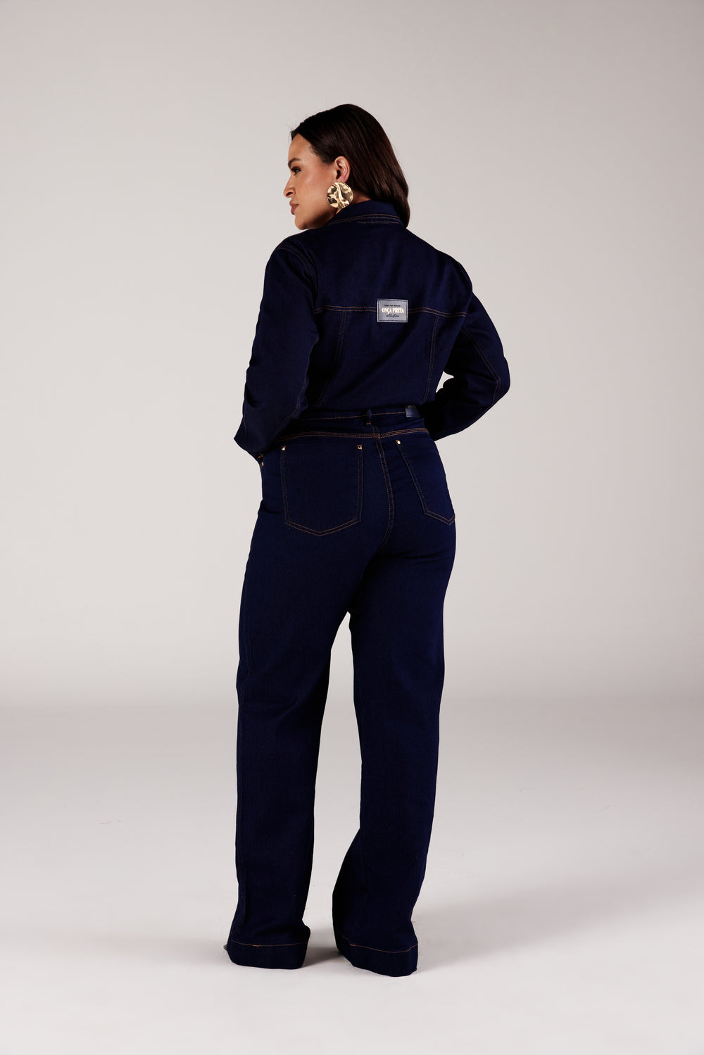 Calça wide leg jeans azul escuro amaciada Curves, vista traseira com jaqueta jeans Onça Preta