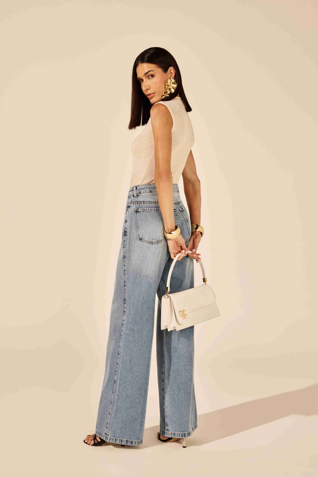 Calça wideleg bordado bolso relógio azul - modelo posando em ambiente urbano com atitude forte Onça Preta
