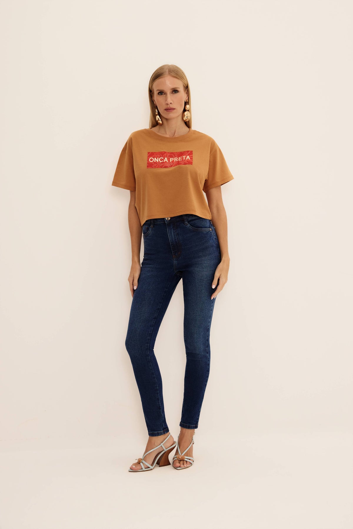 Calça jeans skinny azul escura de cintura alta com cinco bolsos, vista de frente

