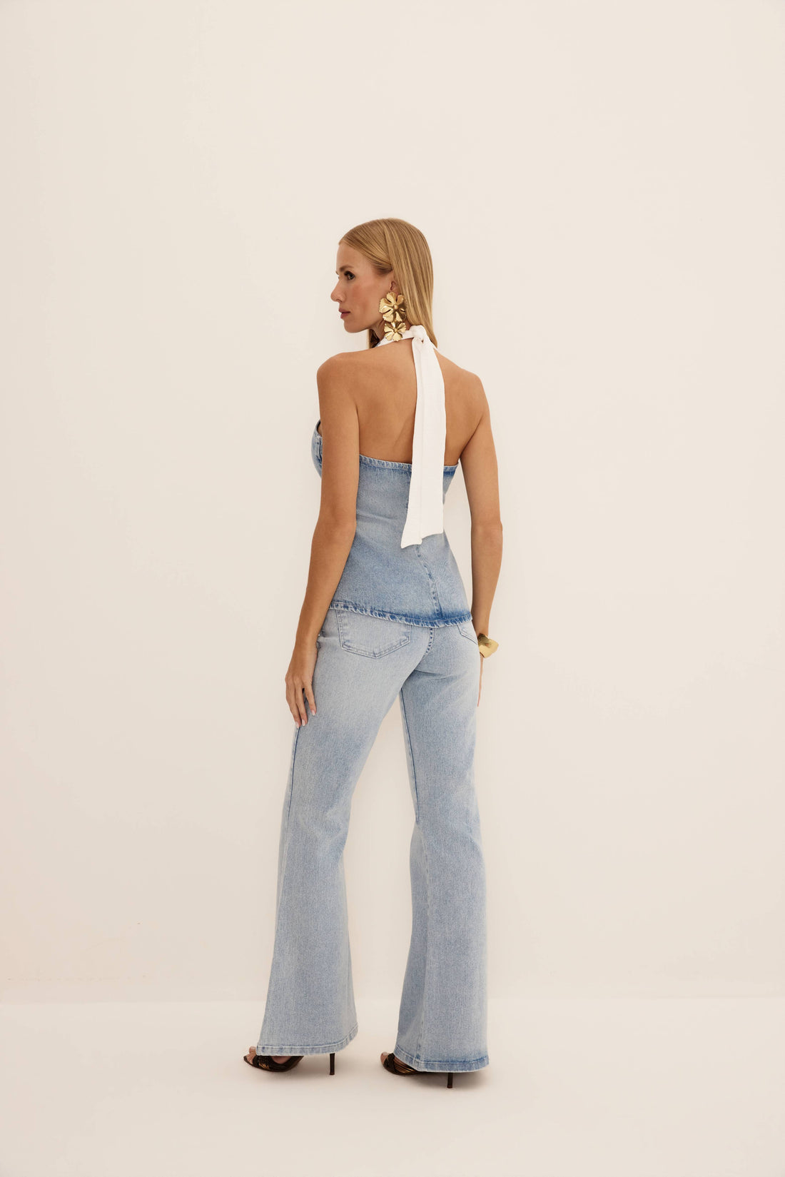 Calça flare básica jeans claro vista de frente, com cintura alta, cinco bolsos e pernas alongadas