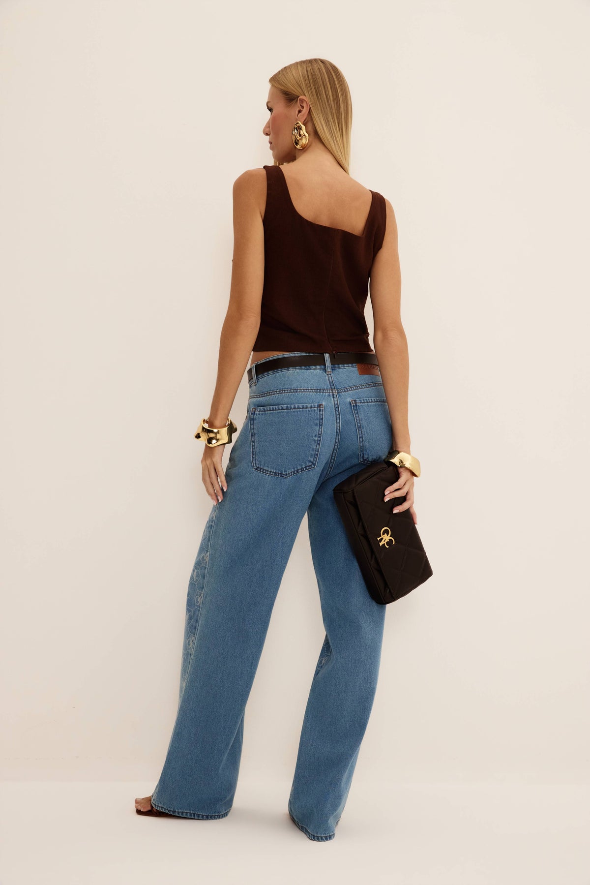 Calça jeans reta azul com bolsos traseiros lisos e laser nas laterais, vista de costas