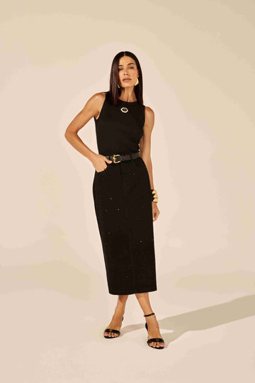 Saia midi jeans preta com detalhes brilhantes de strass, modelagem justa, em fundo neutro Onça Preta.
