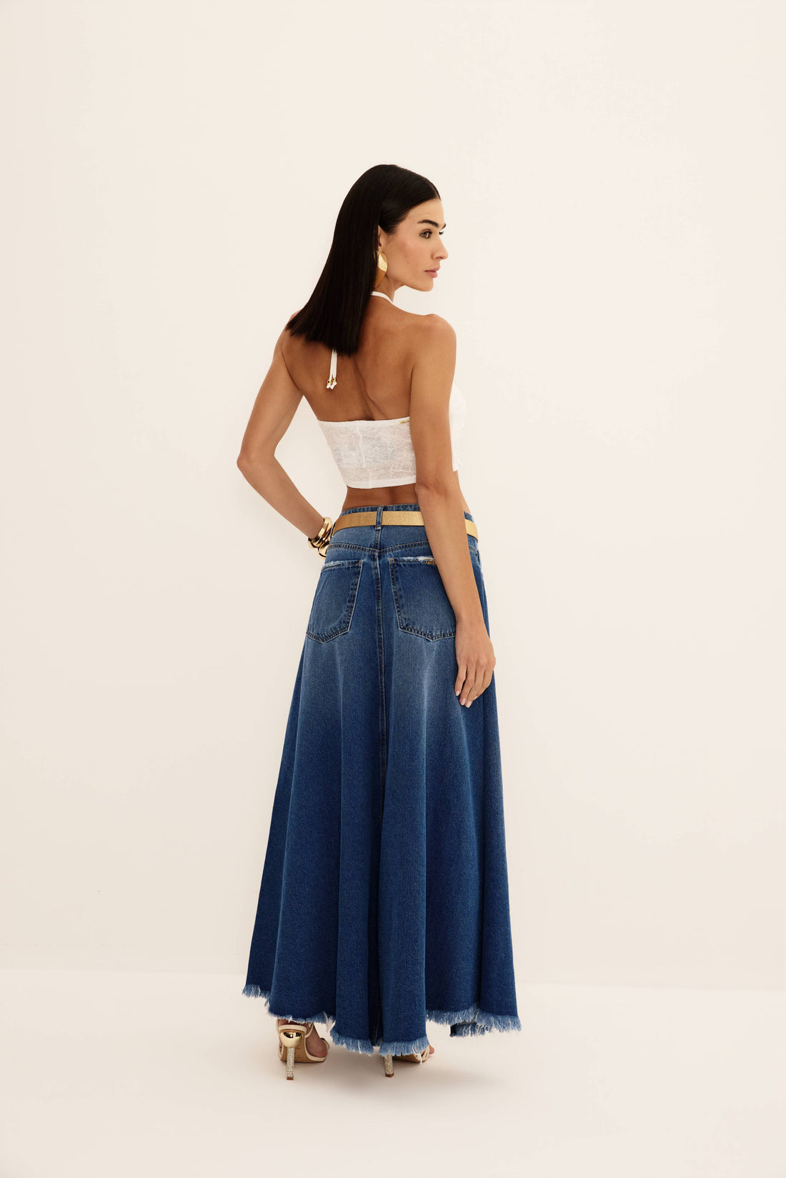 Saia jeans longa azul evasê com abertura frontal e barra desfiada, vista de frente com cinto
