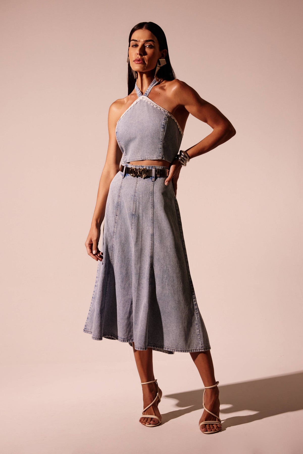 Saia jeans midi godê clara com recortes verticais e cintura alta, vista de frente com cinto