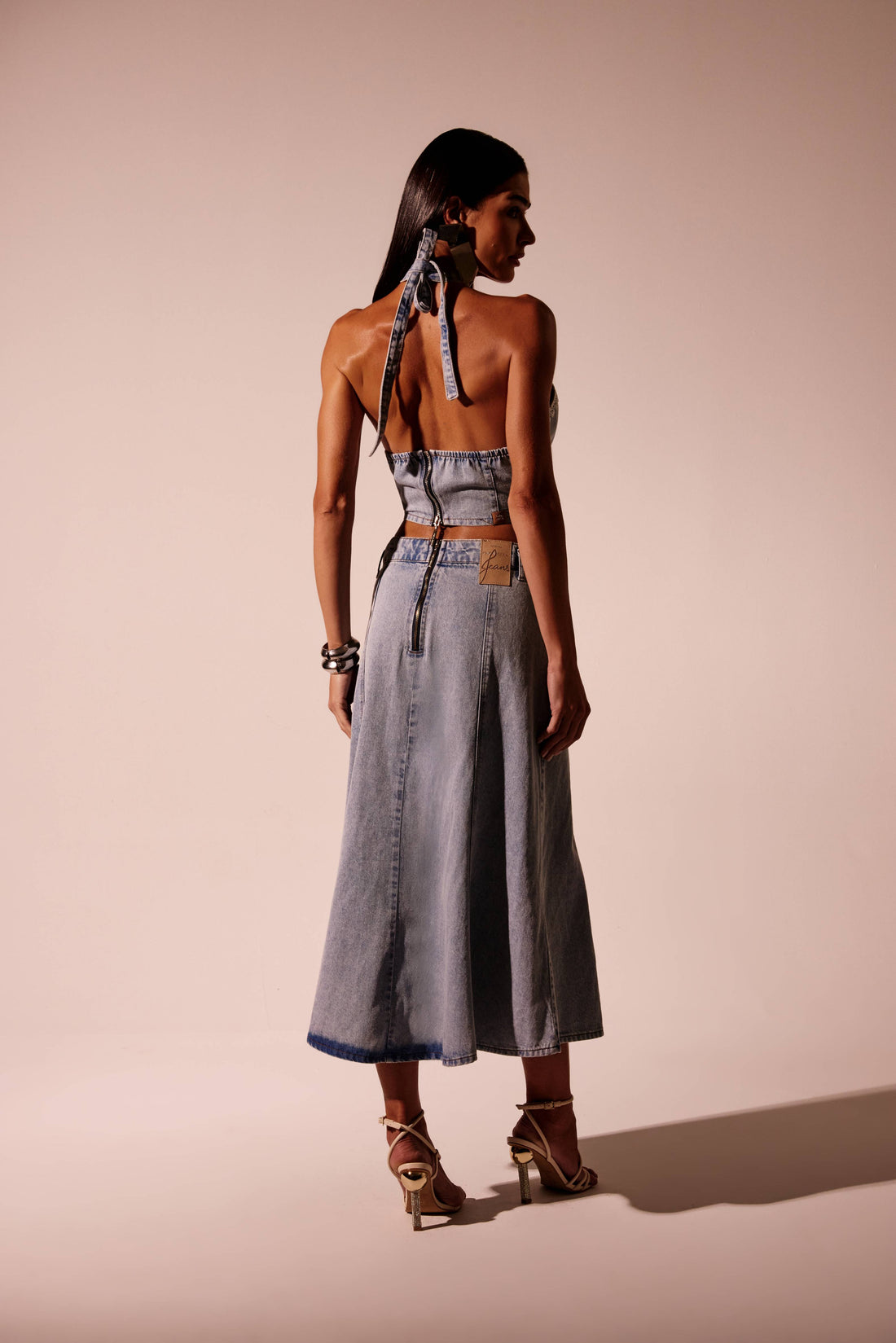 Saia jeans midi godê clara com recortes verticais e cintura alta, vista de frente com cinto
