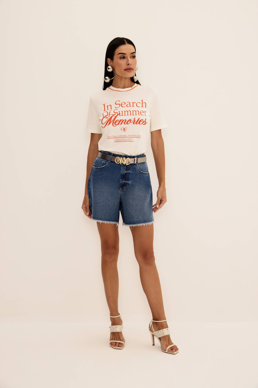 Shorts jeans azul de cintura alta com barra desfiada e perna ampla, vista de frente com cinto
