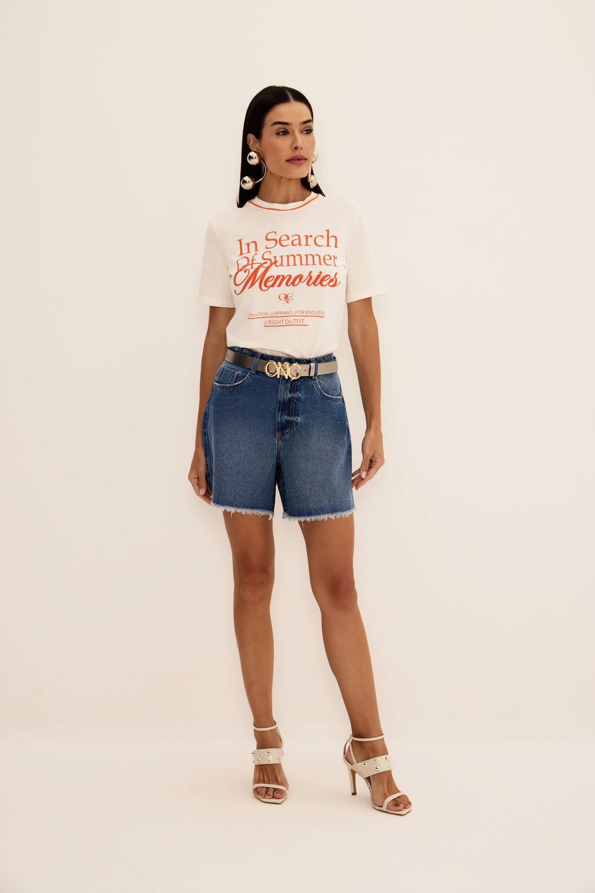 Shorts jeans azul de cintura alta com barra desfiada e perna ampla, vista de frente com cinto