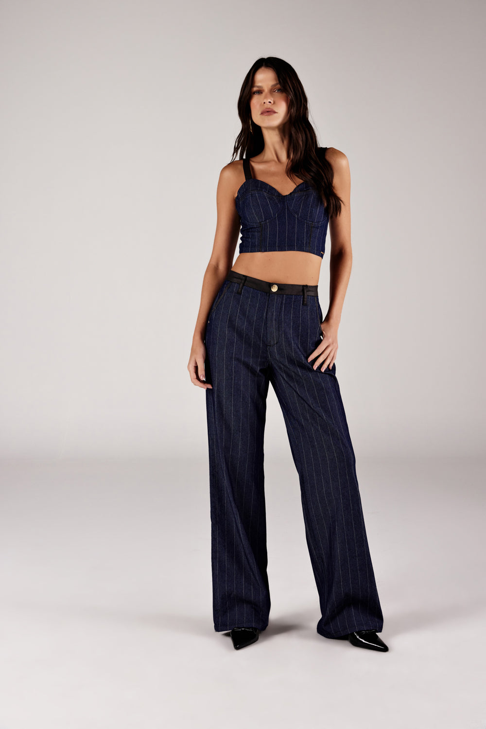 Top corselet jeans listrado azul marinho, look de frente com calça reta Onça Preta