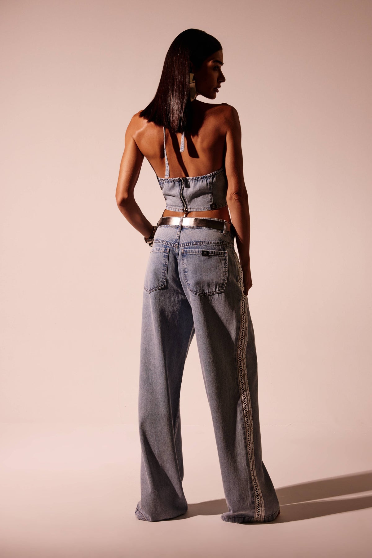 Top jeans claro frente única com costas abertas, amarração no pescoço e zíper aparente, vista de costas

