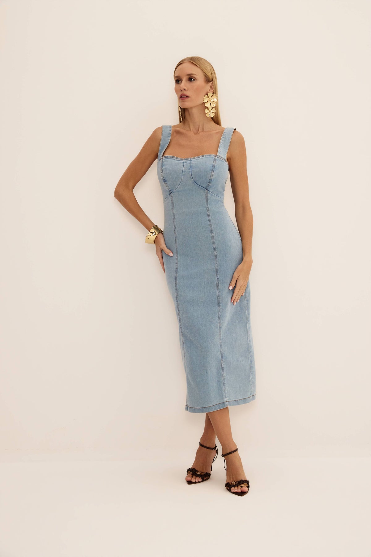 Vestido midi corselet jeans claro visto de frente, com decote coração, alças largas e recortes