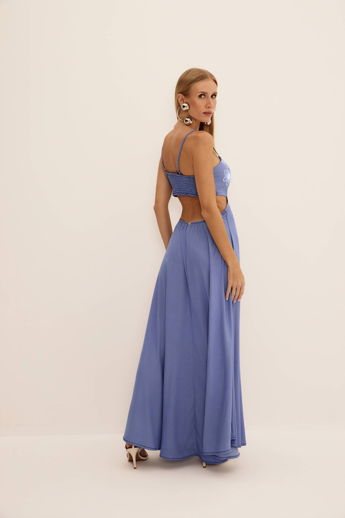Vestido longo com aplicação puff jeans azul visto de costas, com lastex, alças finas e costas vazadas
