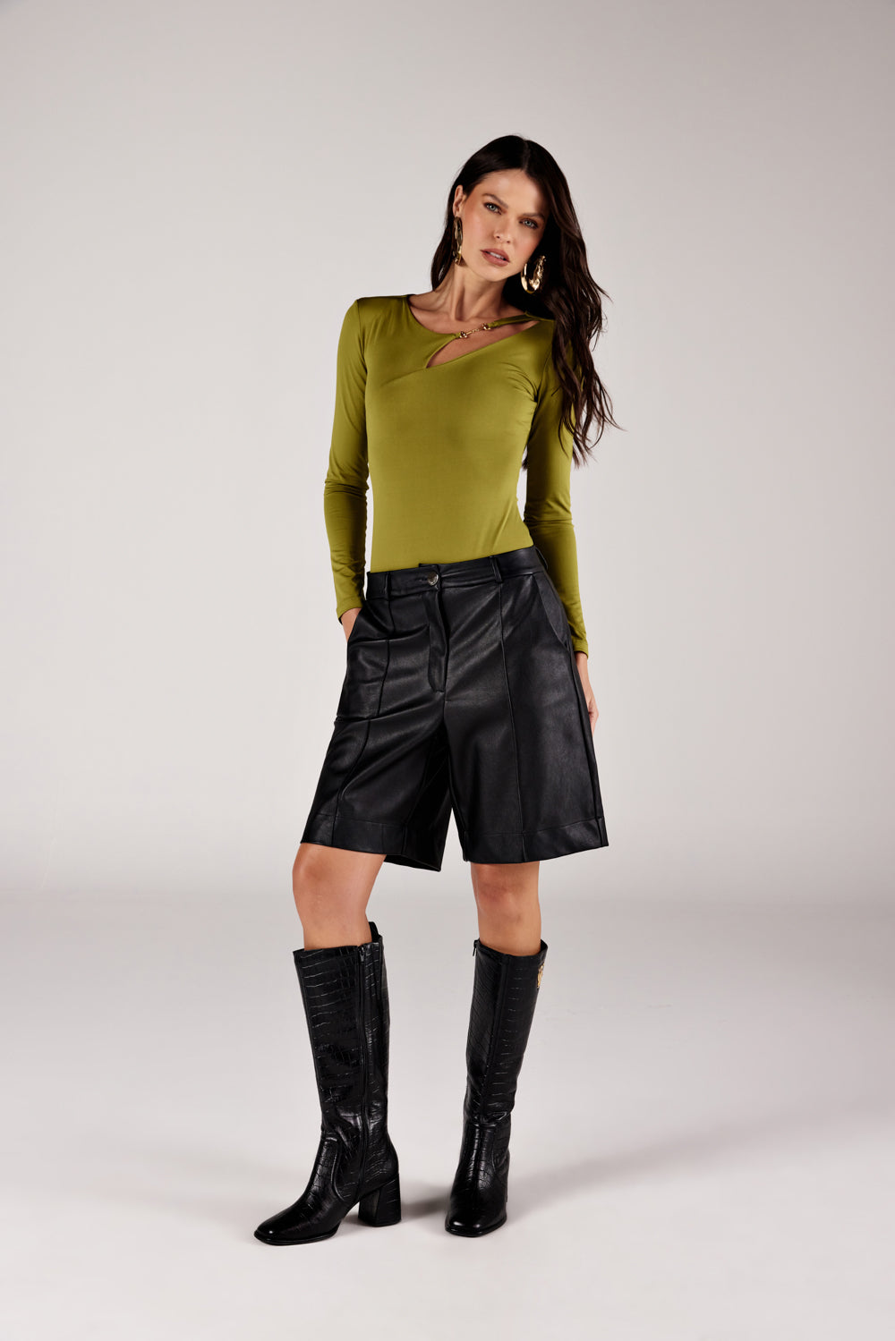 Body verde oliva decote cut out, look de frente com short em couro preto Onça Preta