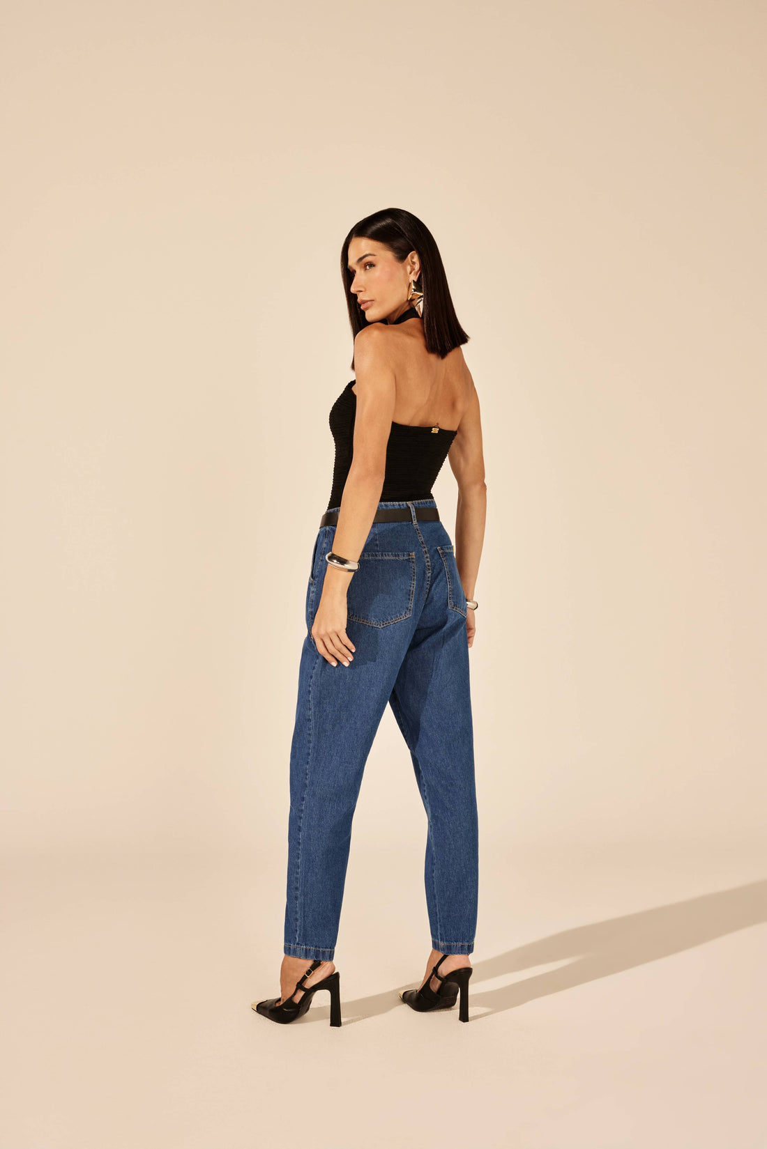 Body preto frente única com argola metálica, look de frente com calça jeans Onça Preta