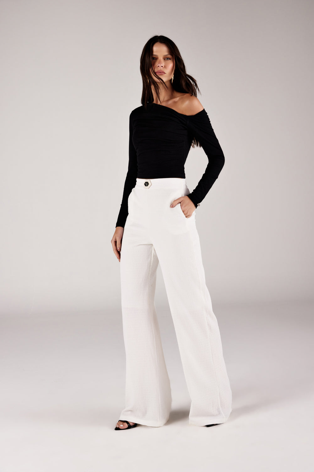 Blusa ombro caído assimétrica, look de frente com calça texturizada Onça Preta