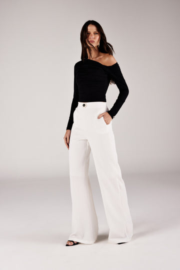 Blusa ombro caído assimétrica, look de frente com calça texturizada Onça Preta