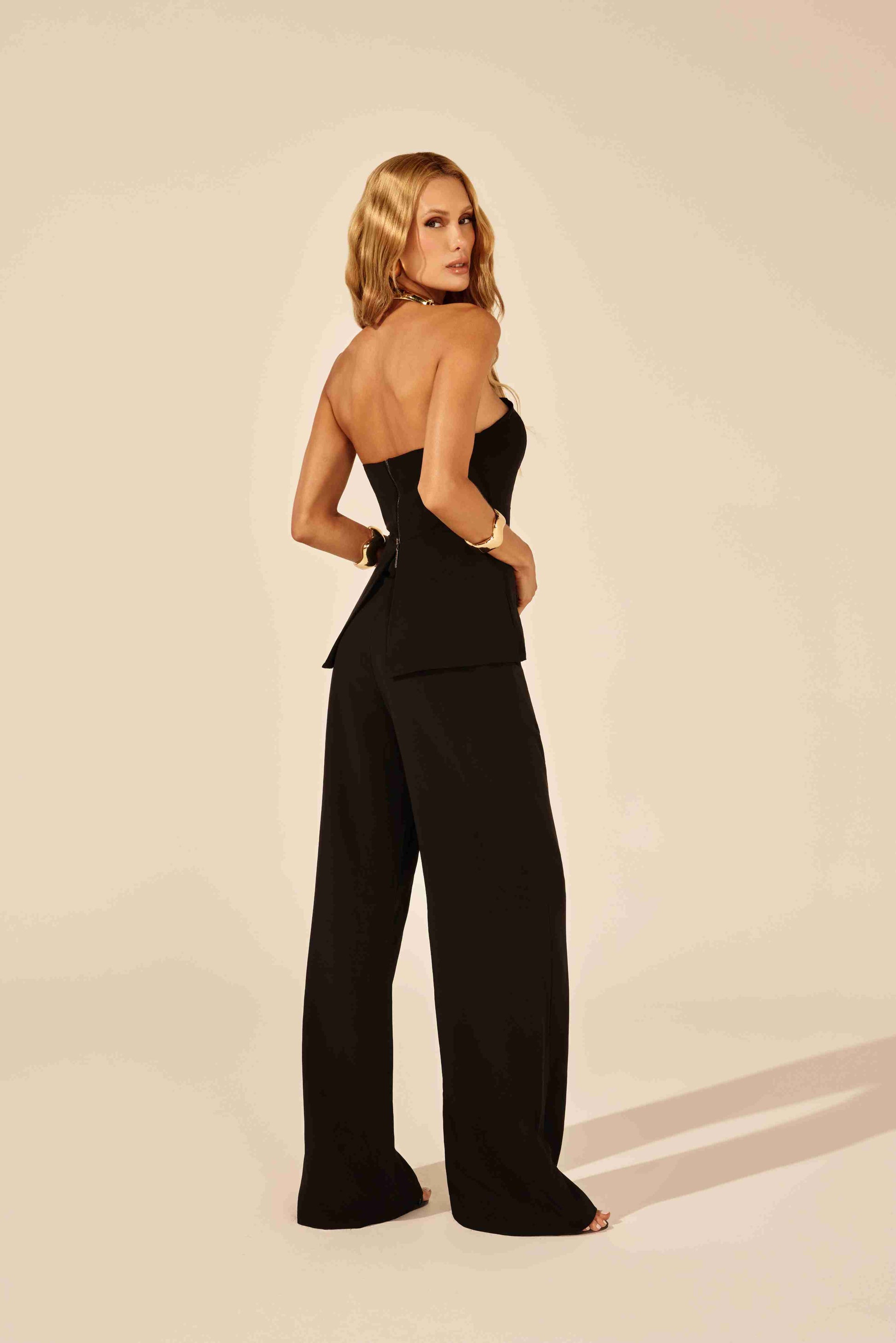 blusa tomara que caia alfaiataria preta - modelo posando confiante com calça social em fundo neutro Onça Preta
