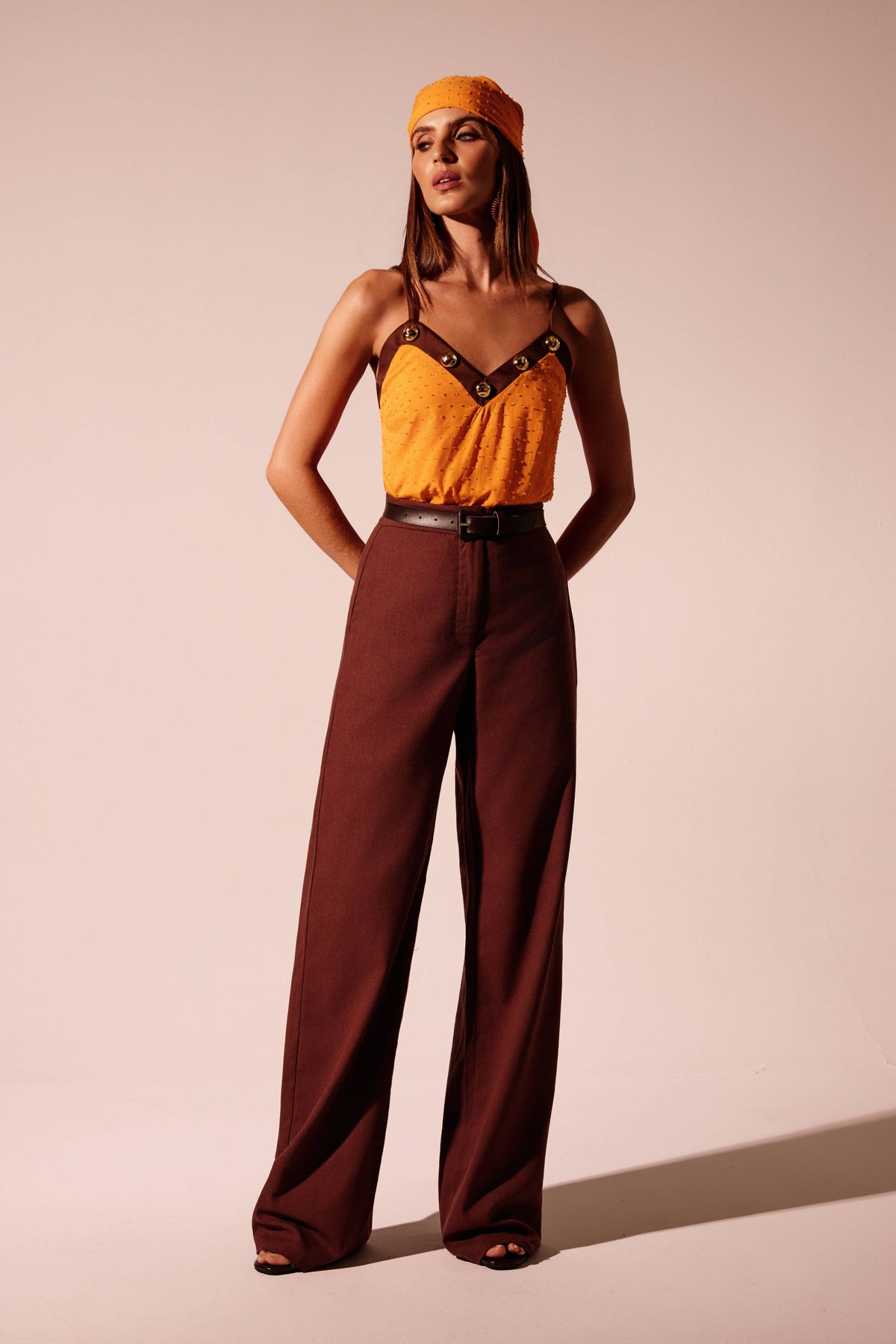 Blusa laranja texturizada de alças finas com decote V marrom em contraste e metais dourados, vista de frente