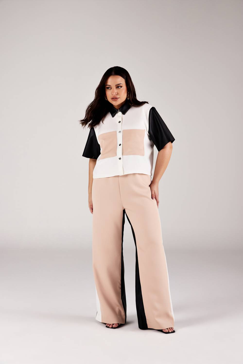 Calça reta color blocking bege e preto com cintura alta, look frontal modelagem Curves Onça Preta