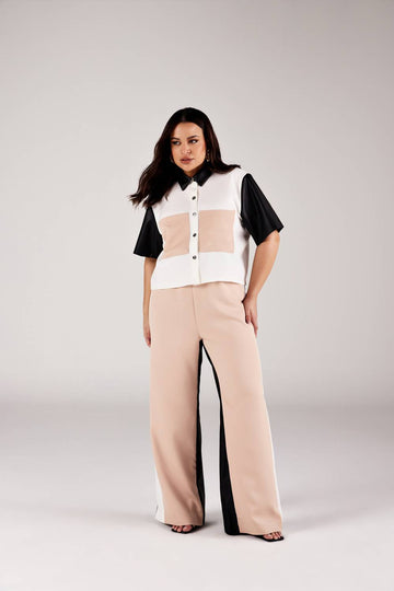 Calça reta color blocking bege e preto com cintura alta, look frontal modelagem Curves Onça Preta