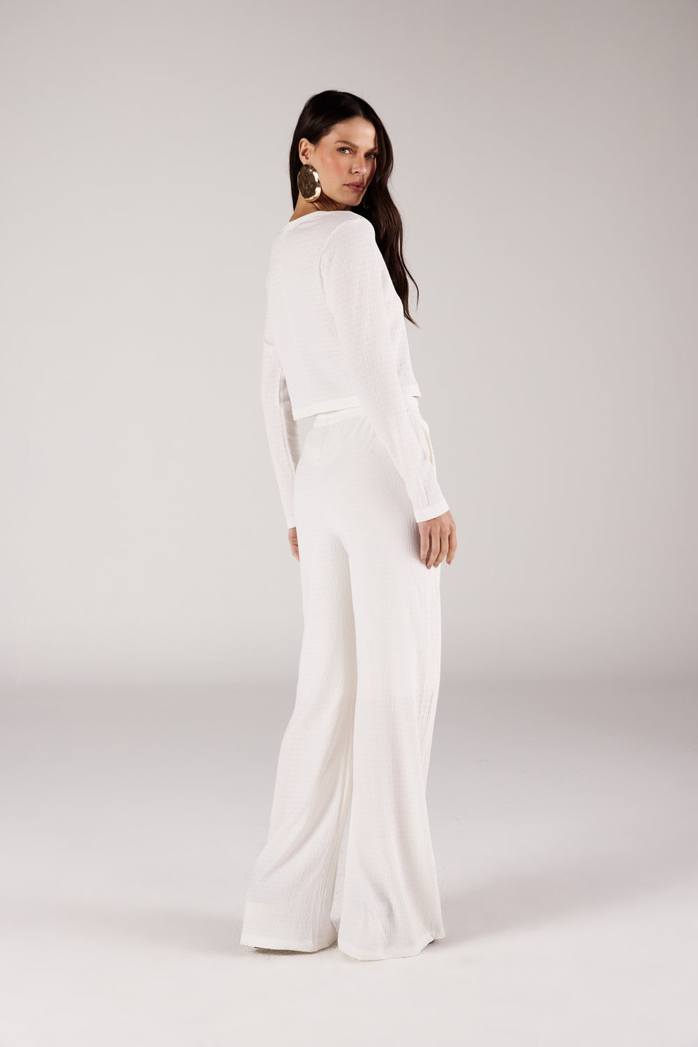 Calça pantalona branca texturizada look completo frontal com blusa Onça Preta