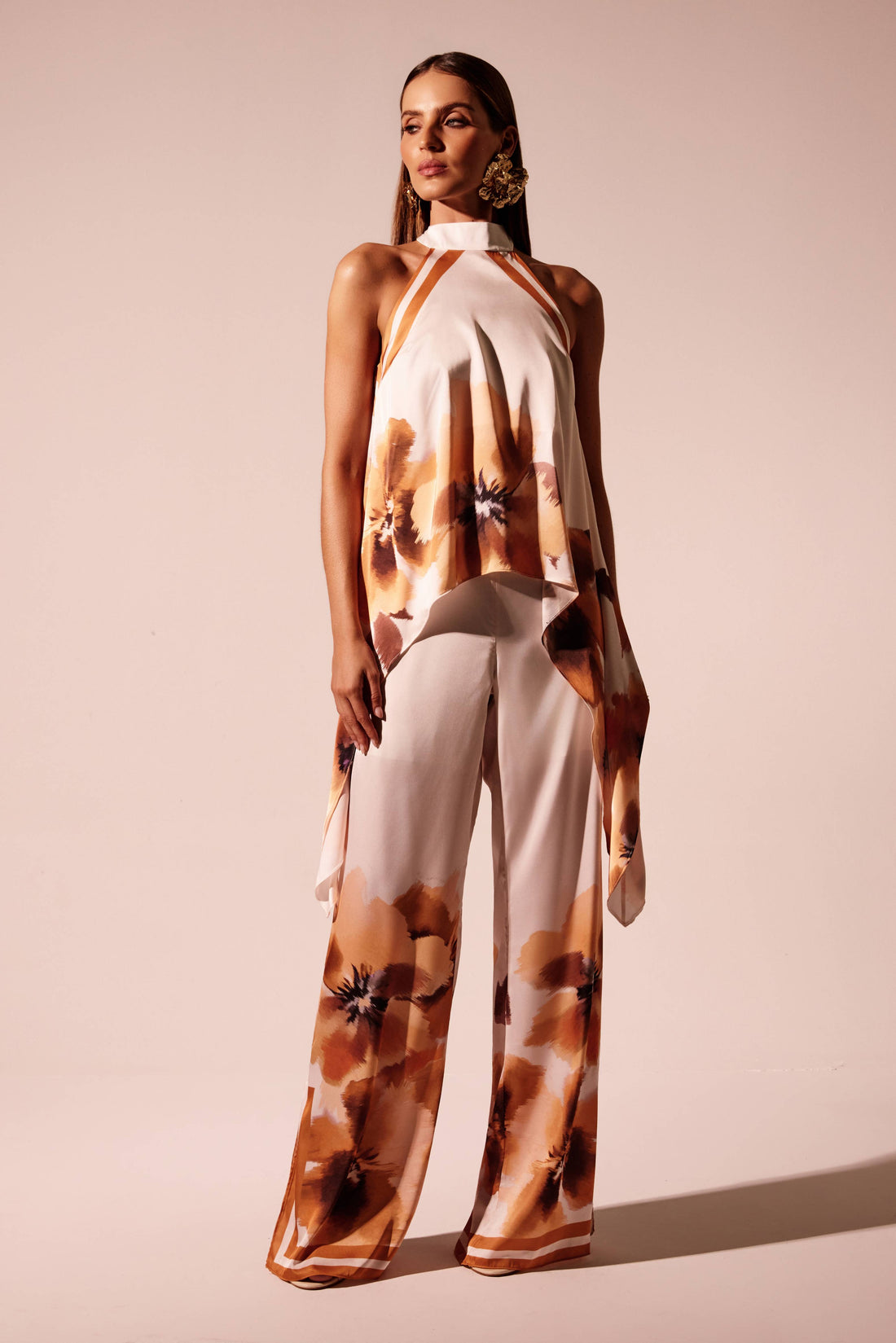 Calça wide leg floral laranja com barra localizada e faixas em contraste, look frontal com blusa frente única Onça Preta