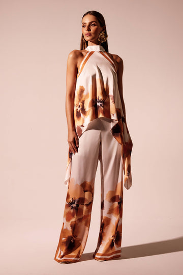 Calça wide leg floral laranja com barra localizada e faixas em contraste, look frontal com blusa frente única Onça Preta