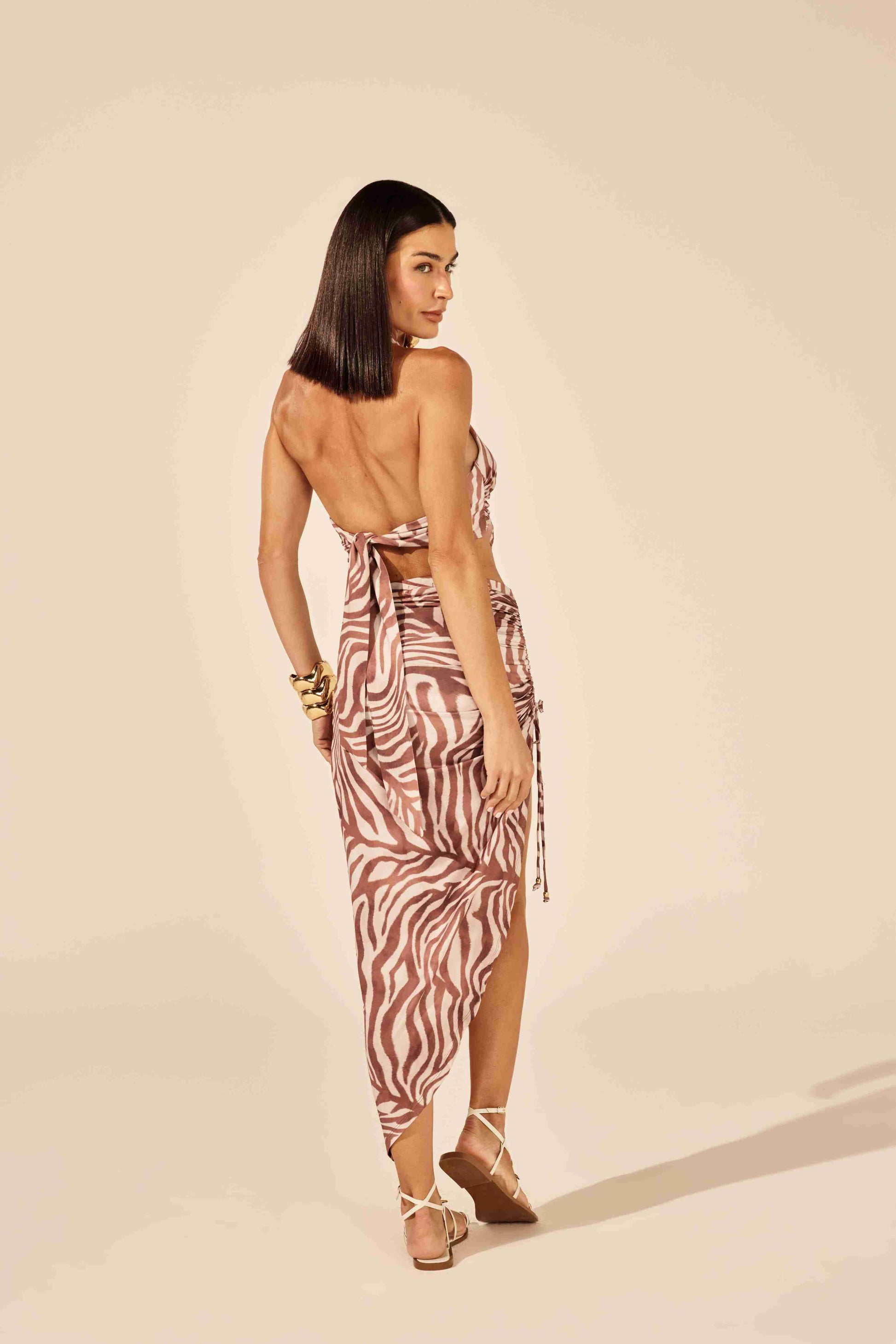 Top transpassado estampado zebra bege - modelo posando com elegância e atitude Onça Preta
