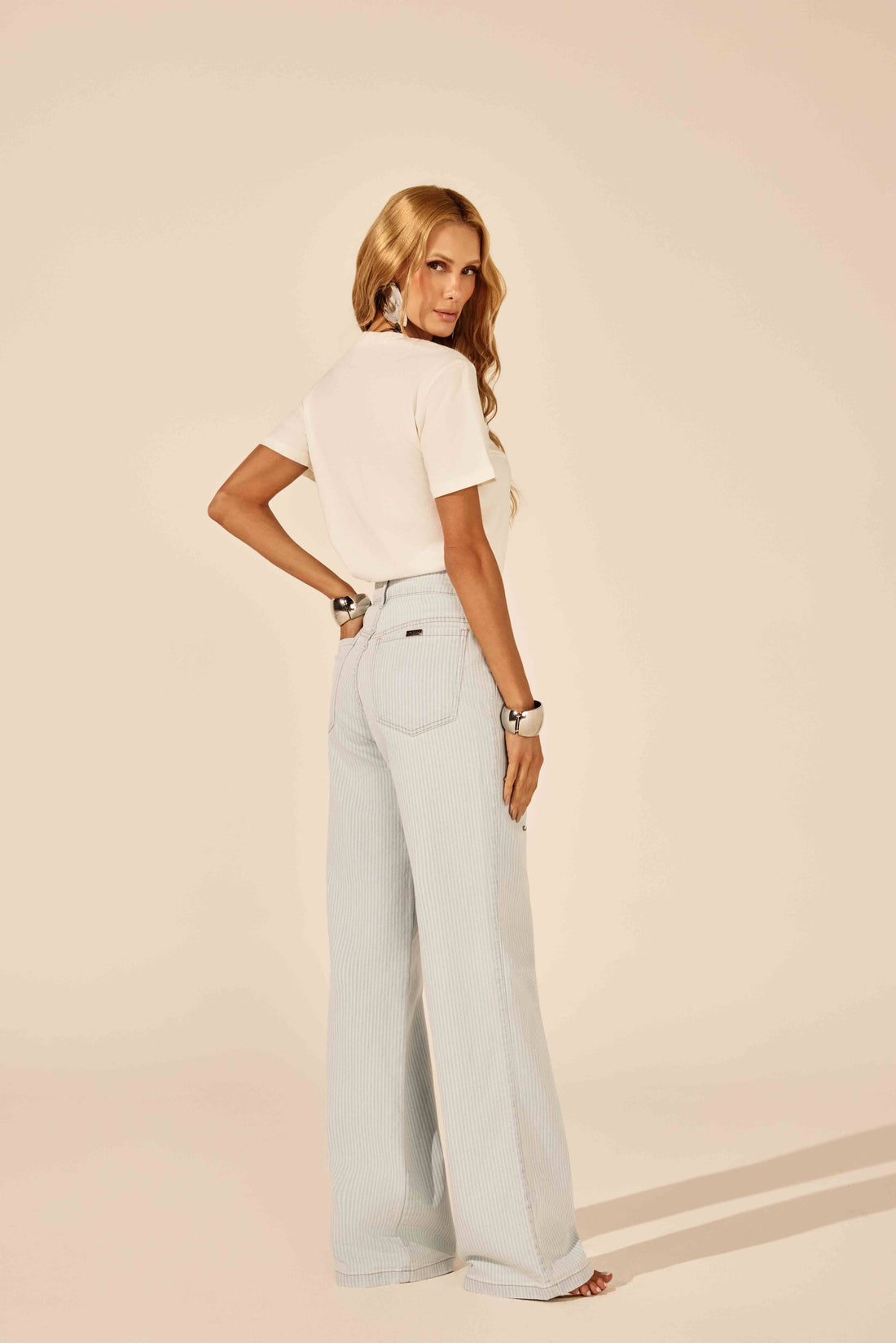 T-shirt off white etiqueta frontal, look de frente com calça jeans listrada Onça Preta