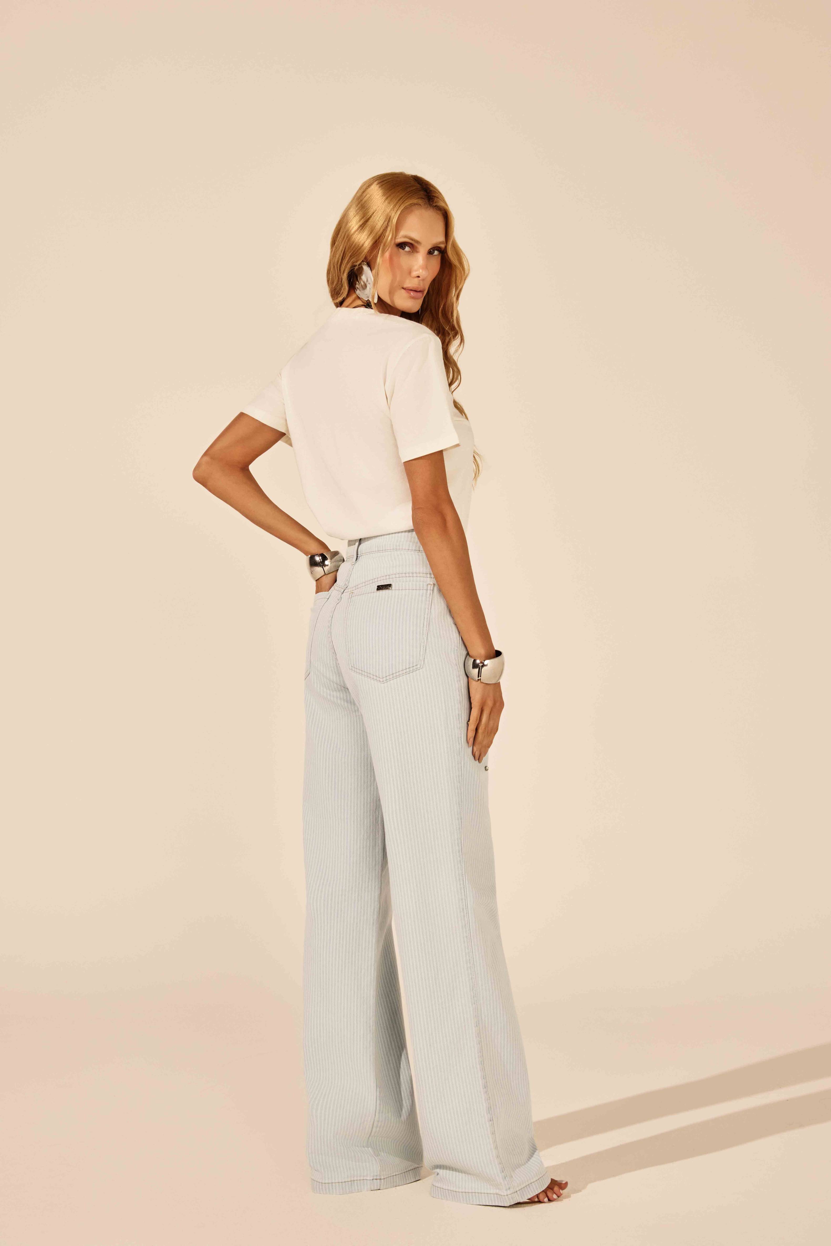 T-shirt off white básica, vista traseira com calça jeans listrada Onça Preta