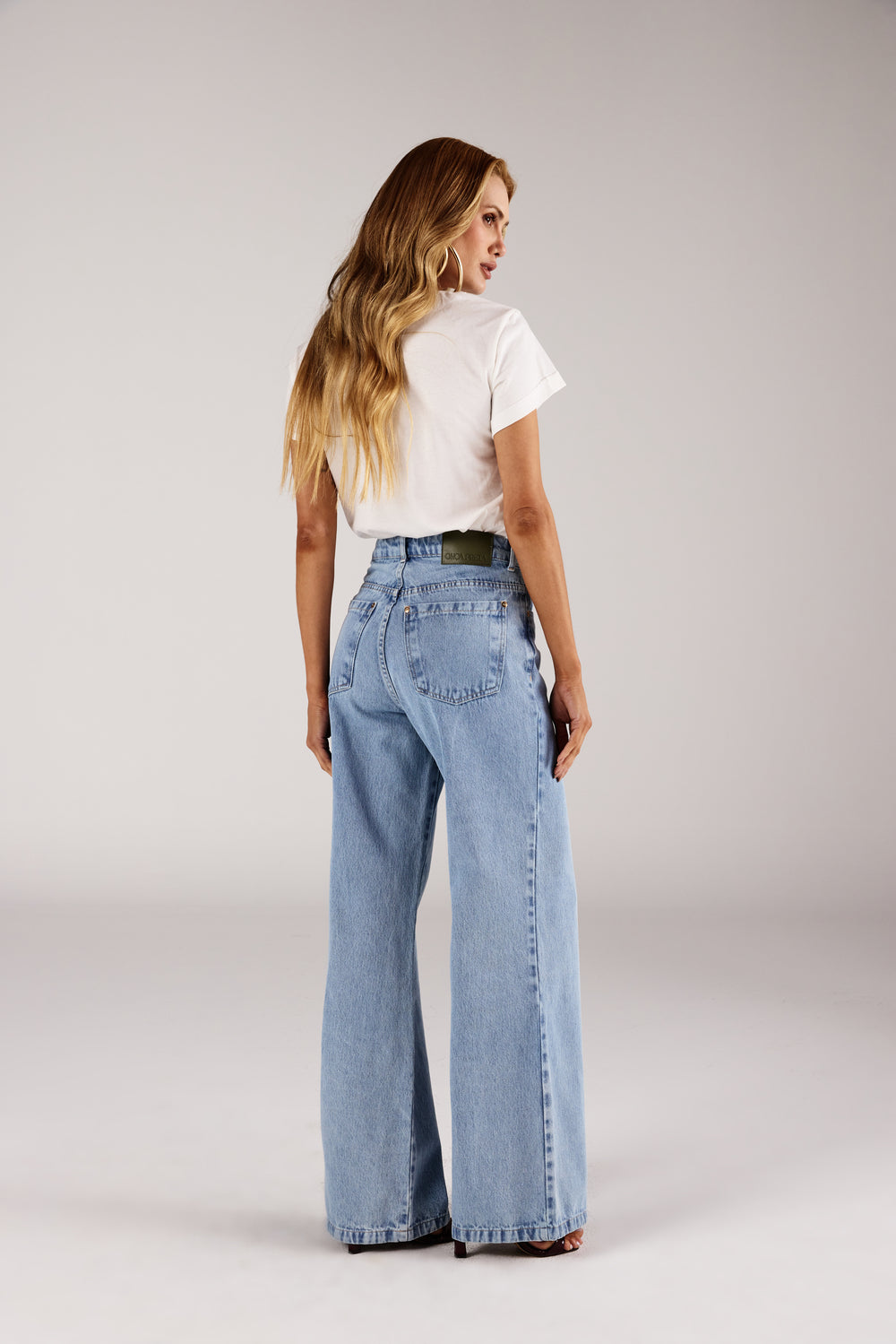 T-shirt off white estampa floral vista traseira com calça jeans wide leg Onça Preta
