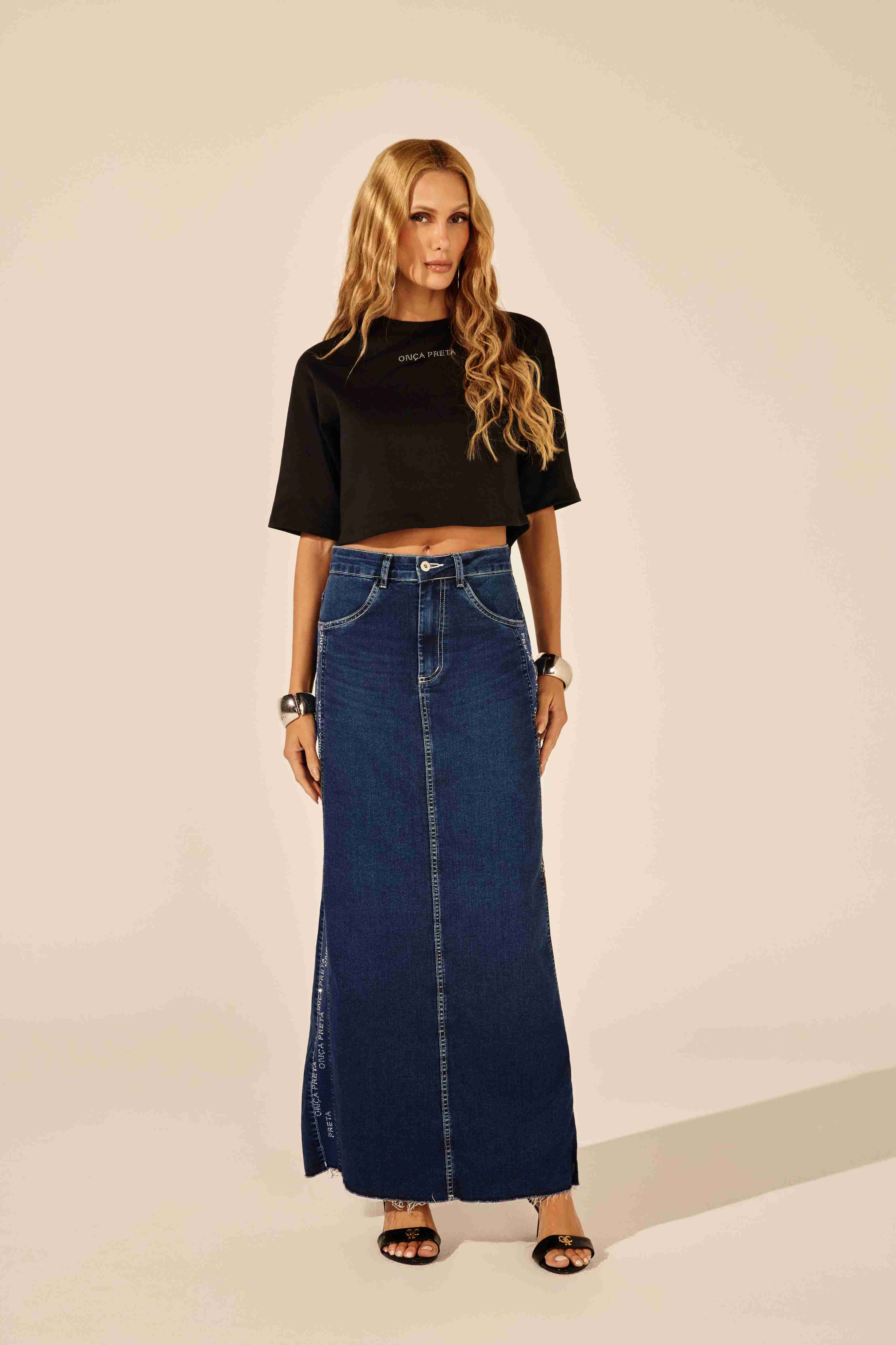 T-shirt feminina preta com detalhes em strass e logomania frontal - modelo veste Onça Preta
