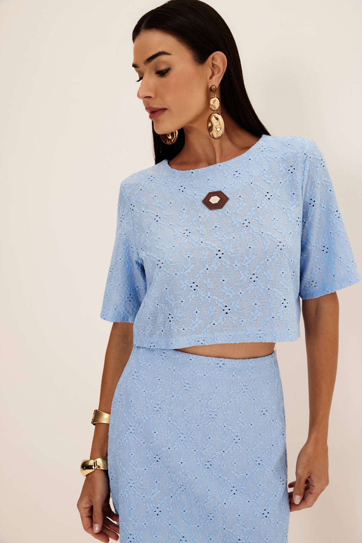 T-shirt cropped em laise azul vista de frente, com decote redondo, etiqueta frontal e mangas curtas