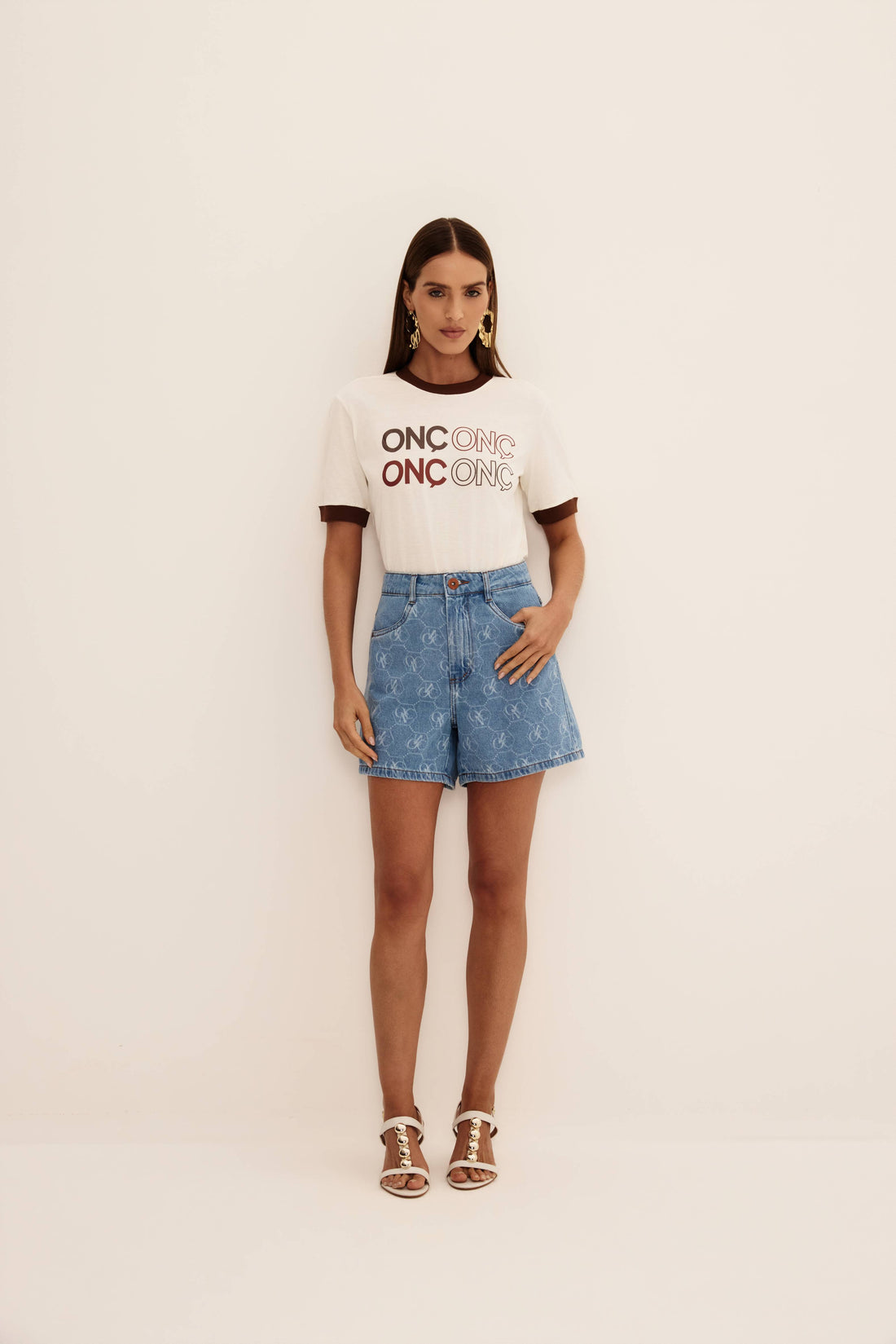 T-shirt off white com silk ONÇ em tons de marrom e ribana marrom na gola e mangas, vista de frente
