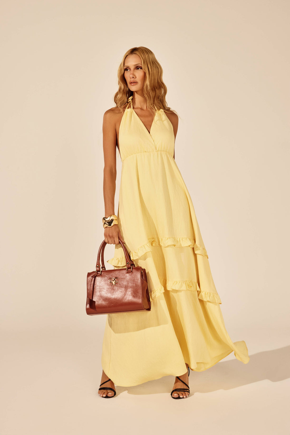 Vestido longo amarelo alça de amarrar decote em V, look de frente com bolsa Onça Preta