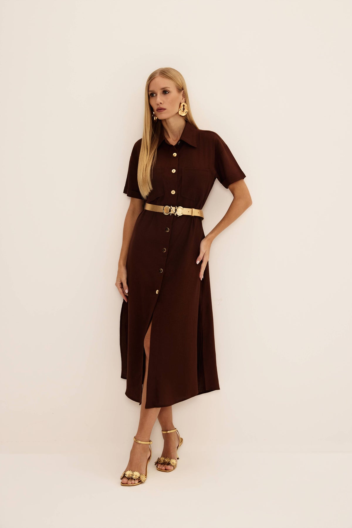 Vestido midi chemise marrom de linho com gola, botões dourados, bolsos no peito e cinto dourado, vista de frente