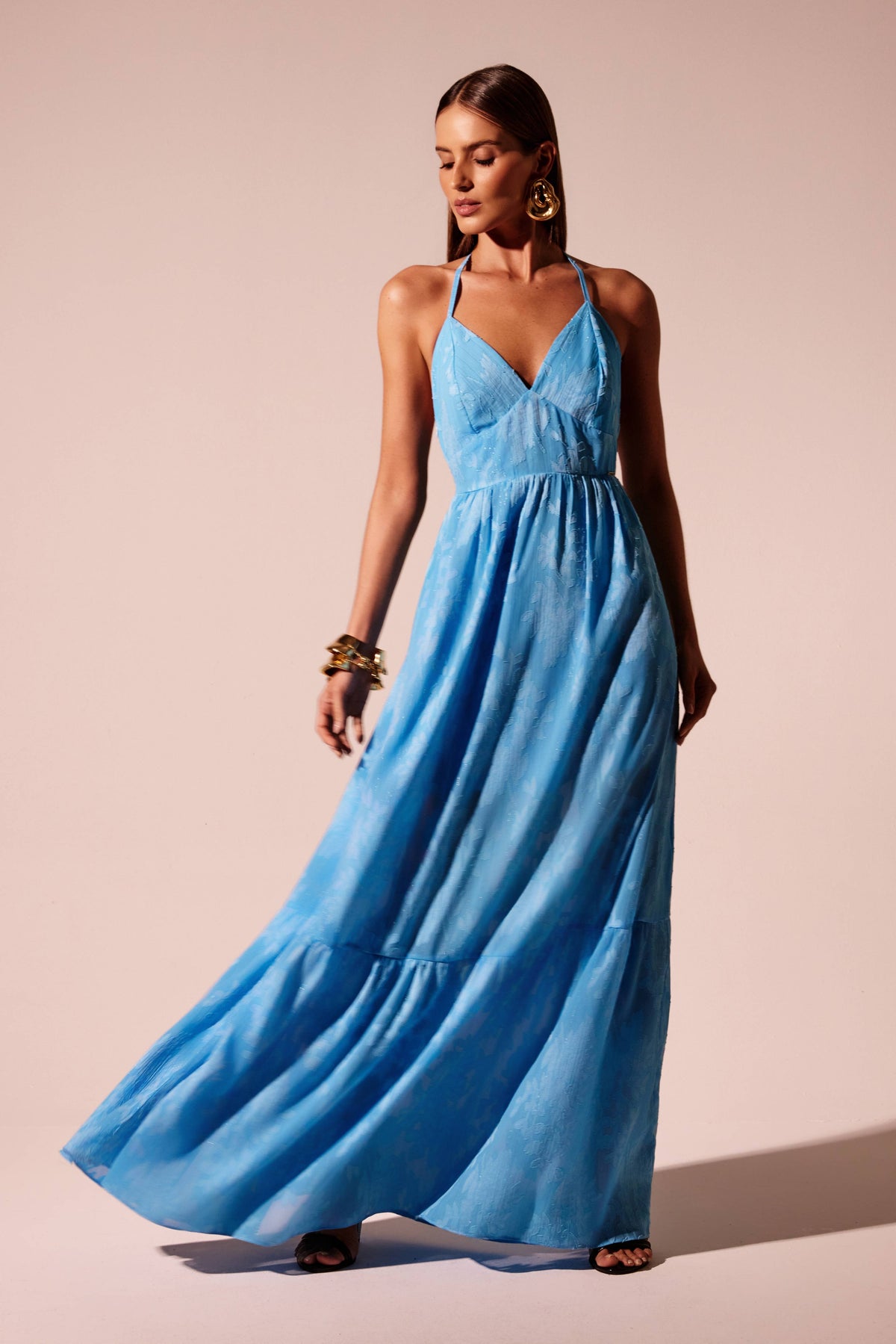 Vestido longo azul decote V com saia fluida em camadas e textura floral, look frontal Onça Preta