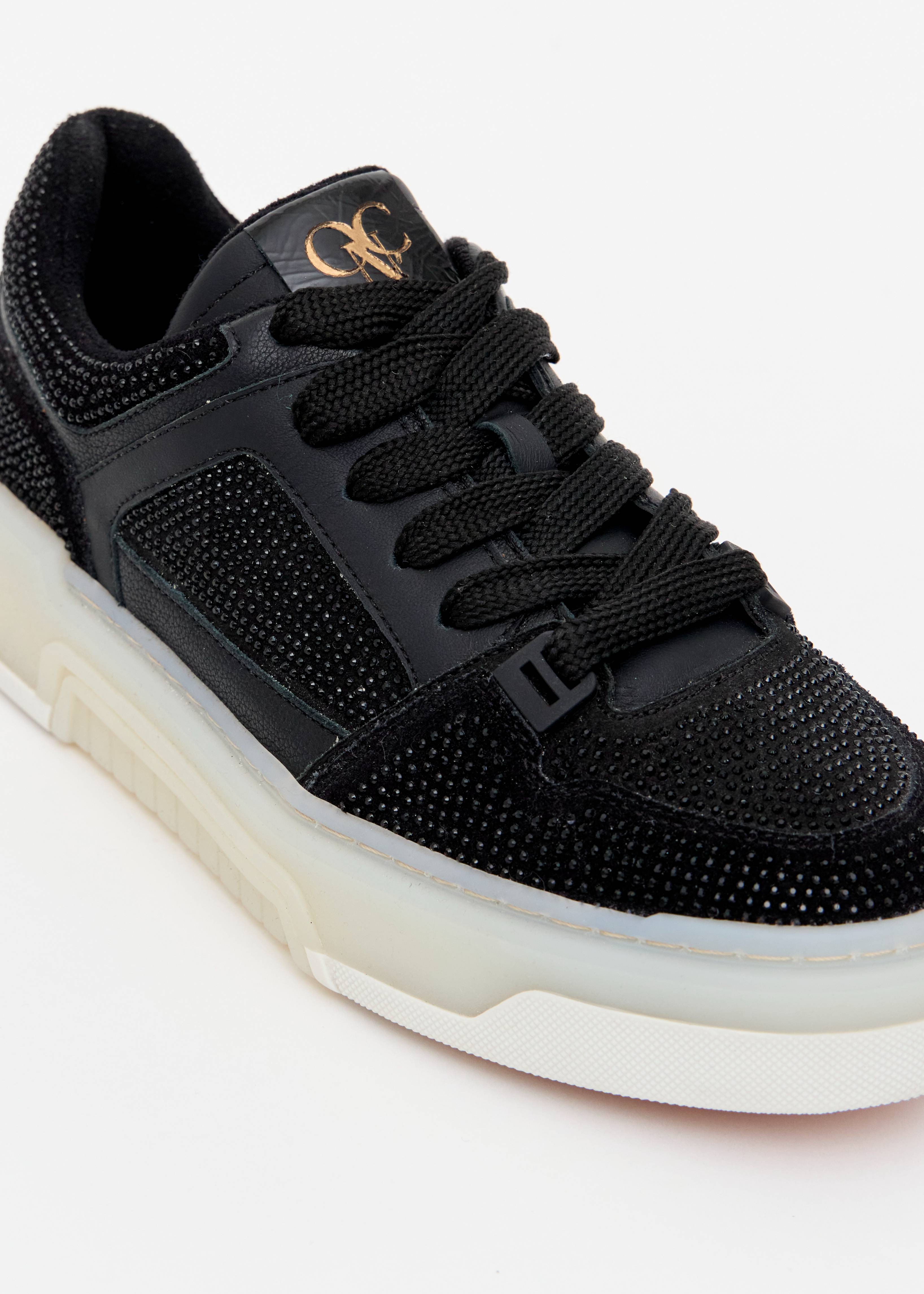 Detalhe strass prata tenis chunky camurca preto monograma OP dourado Onça Preta